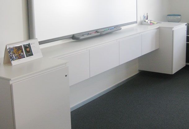 Specialdesignet AV-skab i møderum til teknisk udstyr samt interaktiv tavle. Hvid Corian og malet mdf